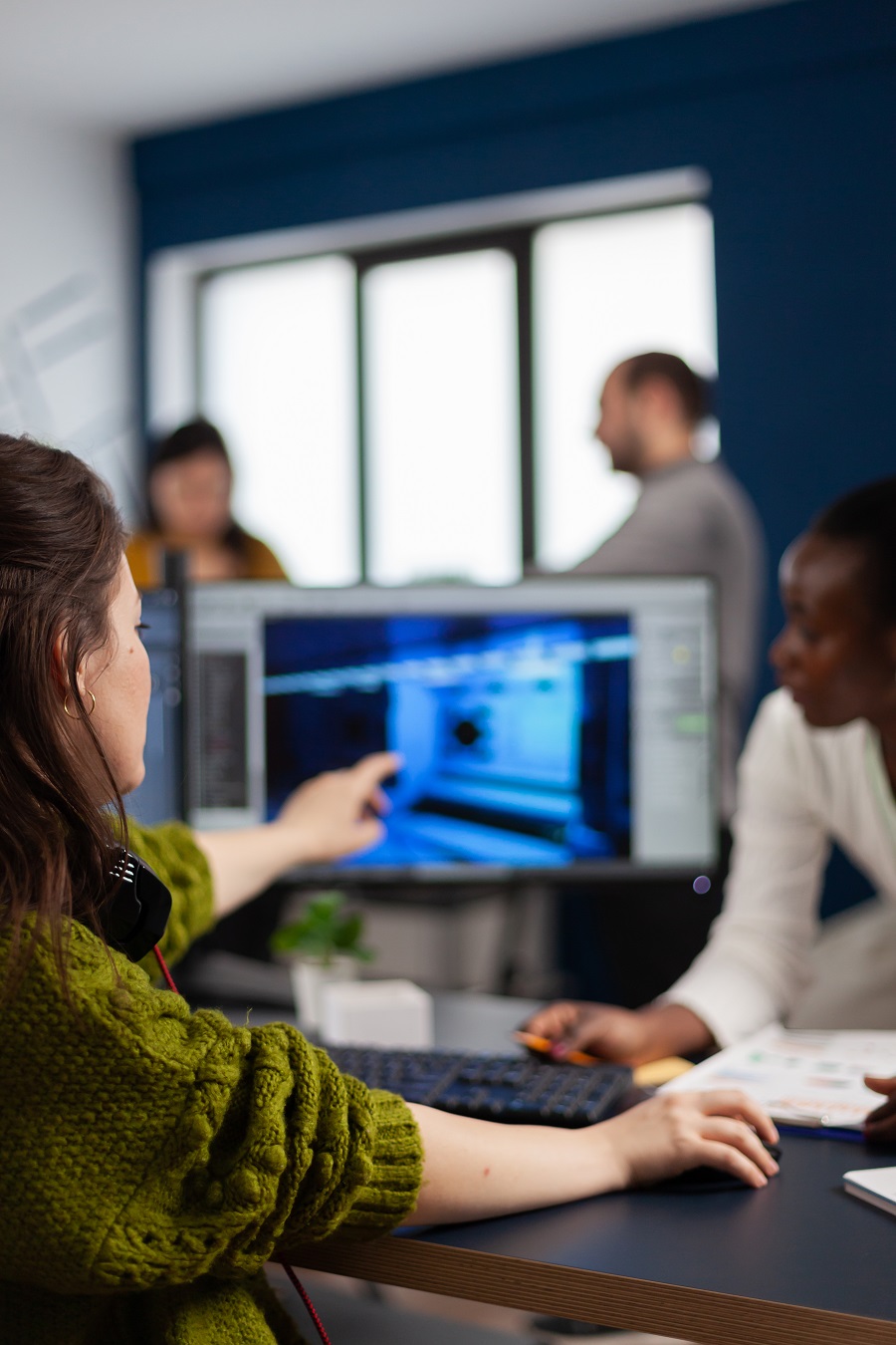 Gamer creator explaning to african worker how develop game level interface